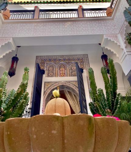 Pokój z obrazem na ścianie i kaktusem w obiekcie Riad Ta'achchaqa w Marakeszu