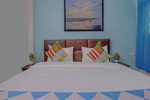 a bedroom with a large bed with colorful pillows at Saket Residency KD Plaza - 6 in New Delhi