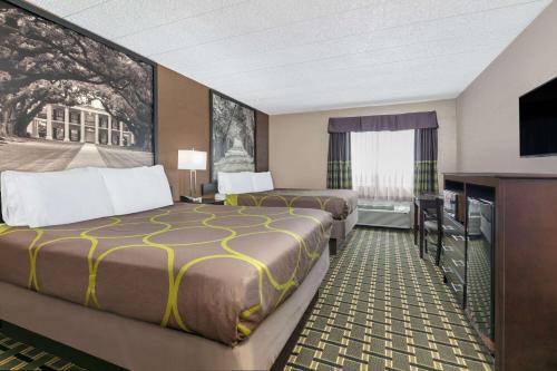 a hotel room with two beds and a flat screen tv at Super 8 by Wyndham Grand Prairie North in Grand Prairie