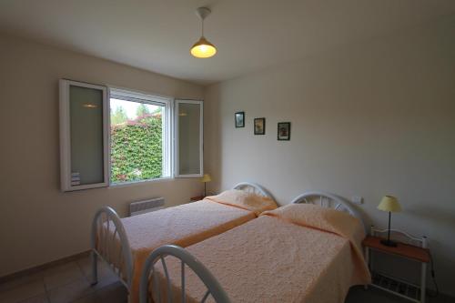 deux lits dans une chambre avec une fenêtre dans l'établissement Clos Christol B, à Graveson