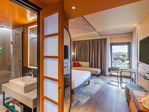um quarto de hotel com uma cama e um lavatório em Novotel Lisboa em Lisboa