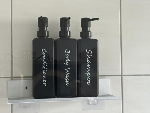two black shampoo bottles sitting on a shelf at Melanies Apartment in Burgsinn