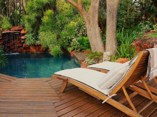 a hammock on a deck next to a swimming pool at Monkey Thorn in Roodeplaat