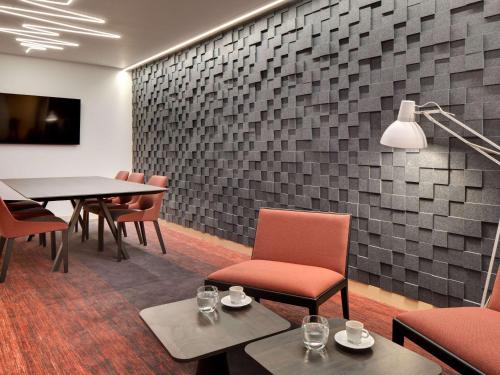 a dining room with a table and chairs and a wall at Mercure Montpellier Centre Comédie in Montpellier