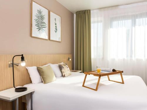 a hotel room with a bed with a table on it at Aparthotel Adagio Access Paris Maisons-Alfort in Maisons-Alfort