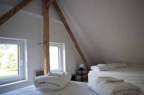 Duas camas num quarto branco com duas janelas em Turistická ubytovna U Tlusťocha em Malá Skála