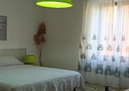 1 dormitorio con 1 cama y una ventana con luz verde en Orbetello Appartamento accogliente con parcheggio gratuito, en Orbetello