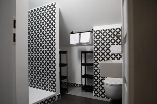 a bathroom with a toilet and a black and white wall at Turistická ubytovna U Tlusťocha in Malá Skála