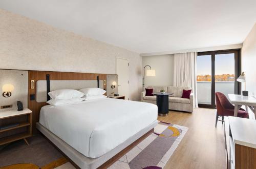 a bedroom with a large white bed and a living room at Hyatt Regency New Brunswick in New Brunswick