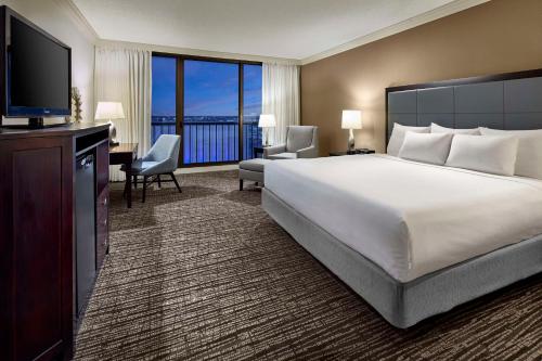 um quarto de hotel com uma cama grande e uma televisão em Hyatt Regency Tulsa Downtown em Tulsa