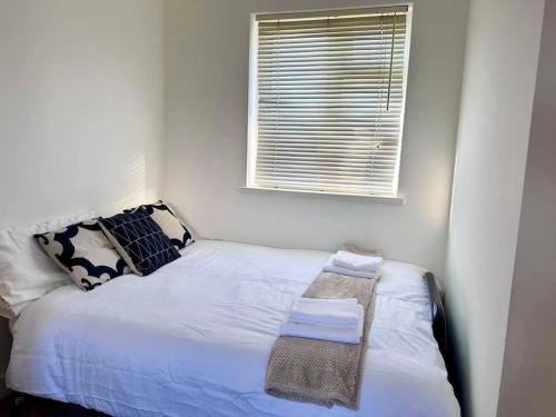 a small bedroom with a bed with a window at Large One Bedroom House near Twickenham stadium in Isleworth