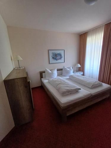 a bedroom with a large bed with white sheets and pillows at Ferienclub Erlenbruck in Hinterzarten