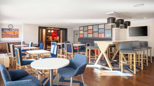 a restaurant with tables and chairs and a tv at Hampton Inn Phoenix Airport North in Phoenix