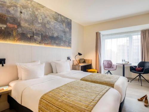 een hotelkamer met een groot bed en een raam bij Mercure Oostende in Oostende