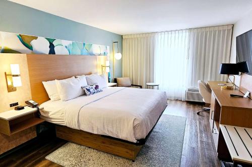 una camera d'albergo con un grande letto e una scrivania di Wyndham Garden Atlanta Airport ad Atlanta