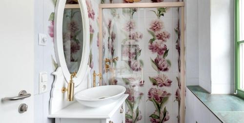 a bathroom with a shower curtain with pink flowers at Hotel am Prinzengarten in Sigmaringen