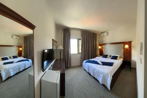 a hotel room with two beds and a flat screen tv at Pasha Boutique Hotel in Amman