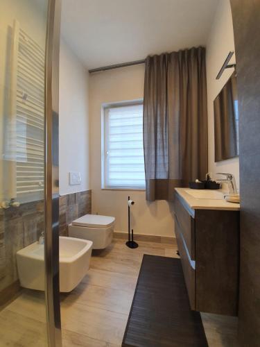 a bathroom with a toilet and a sink and a tub at Bergamo - La Casa Di Gianna in Nembro