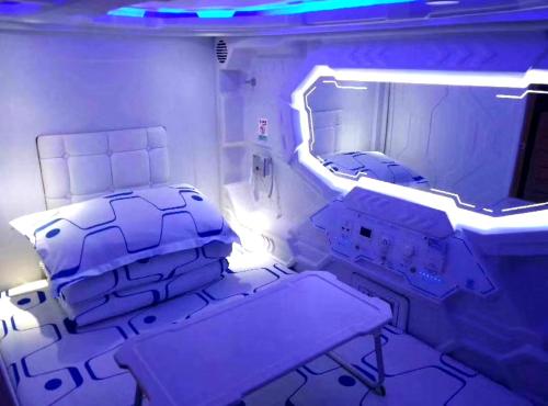 a hospital room with two beds and a mirror at Xi'an Xianyang International Airport Space Capsule Hotel in Xi'an