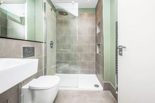 a bathroom with a toilet and a shower at Pass the Keys Modern Home-Private Parking-Garden in London