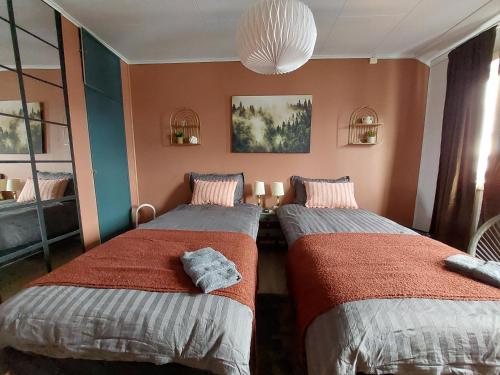 a bedroom with two beds and a chandelier at The perfect stop in Lødingen