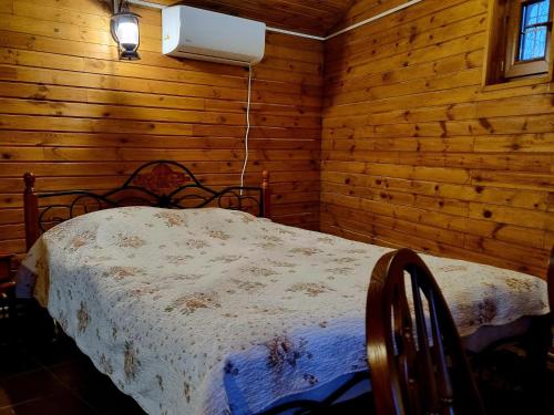 a bedroom with a bed in a log cabin at Krolichya ferma in Ivancea