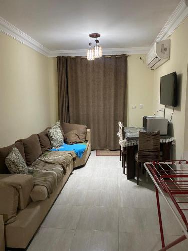 a living room with a couch and a table at Laserina Palm Beach for families only ground floor with big garden in Ain Sokhna