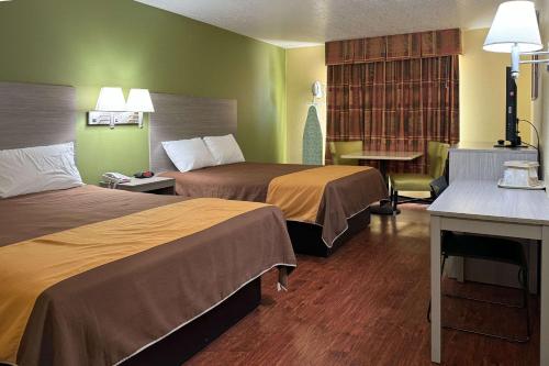 Cette chambre comprend deux lits et un bureau. dans l'établissement Rodeway Inn, à Moriarty