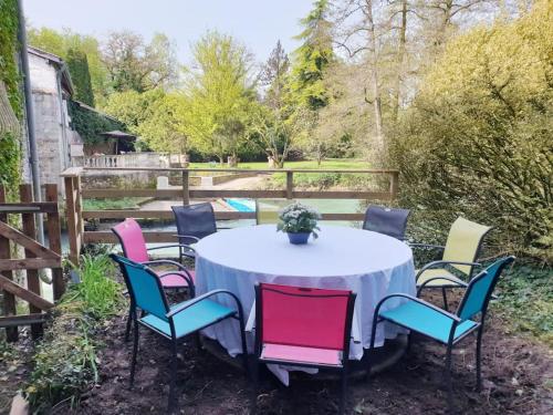 a white table and chairs with a white table and chairs at Moulin de Courcelles in Aubréville