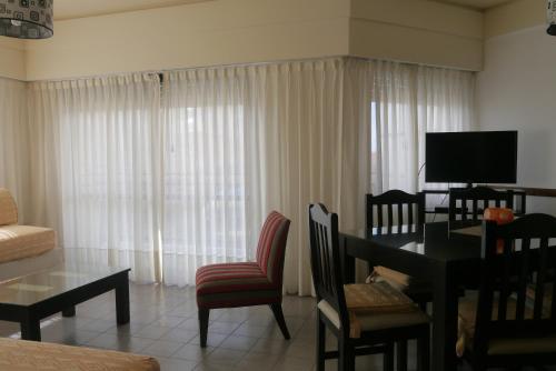 a living room with a dining table and a living room with a television at Club Sol Mar Del Plata in Mar del Plata