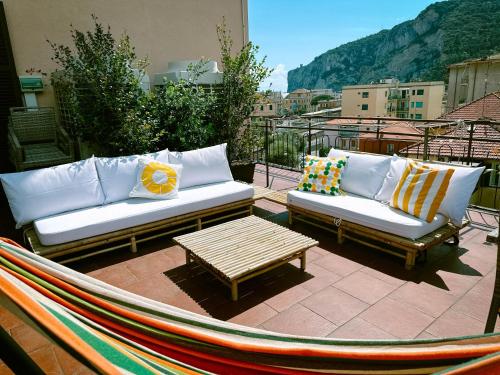 2 canapés et une table basse sur une terrasse dans l'établissement Hotel San Giuseppe, à Finale Ligure
