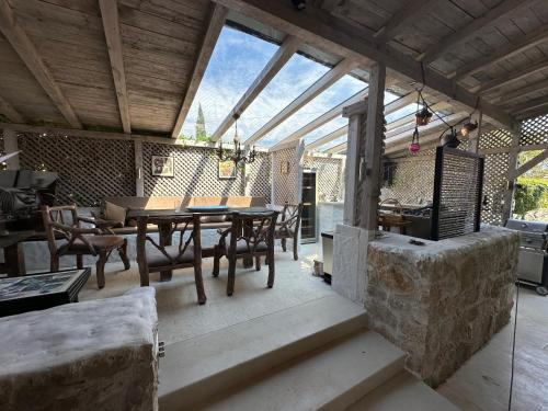 a dining room with a table and chairs on a patio at Villa Orly in Franciskovići