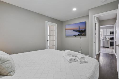 a white bedroom with a large bed with two towels on it at Charming Retreat in the Heart of Des Plaines residence in Des Plaines