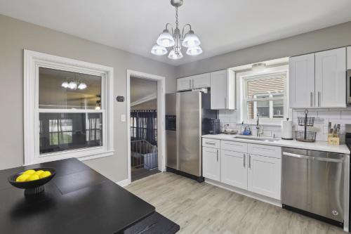 a kitchen with white cabinets and stainless steel appliances at Charming Retreat in the Heart of Des Plaines residence in Des Plaines