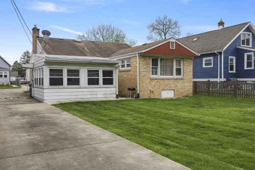 a blue and white house with a yard at Charming Retreat in the Heart of Des Plaines residence in Des Plaines