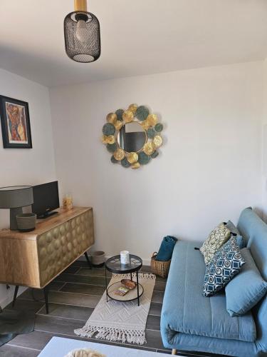 un salon avec un canapé bleu et un miroir dans l'établissement Casa Effet Mer, à Bastia