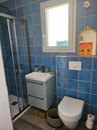 La salle de bains est pourvue de carrelage bleu, de toilettes et d'un lavabo. dans l'établissement Casa Effet Mer, à Bastia
