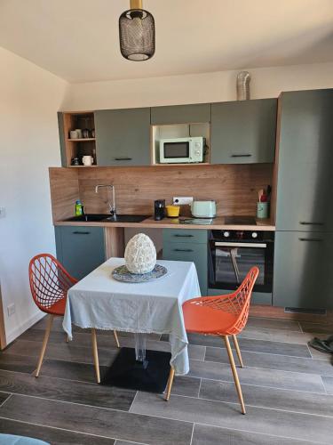 une cuisine avec une table, deux chaises et une table. dans l'établissement Casa Effet Mer, à Bastia