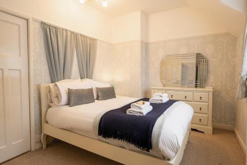 a bedroom with a bed with a mirror and a dresser at Lovely cosy 2 bed cottage on the Wirral Peninsula in Birkenhead