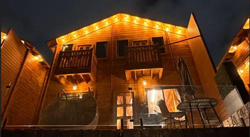 a building with lights on top of it at night at KRZ Cottages أكواخ الكرز in Ash Shafa