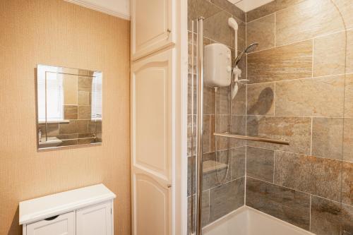 a bathroom with a shower and a toilet and a sink at Lovely cosy 2 bed cottage on the Wirral Peninsula in Birkenhead