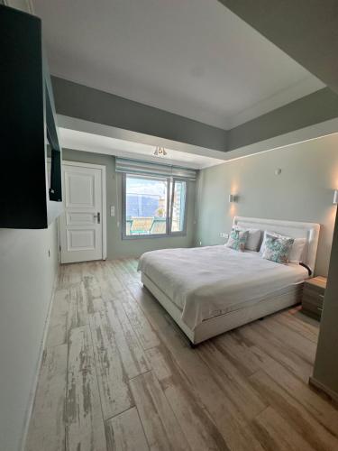 a bedroom with a large bed and a large window at Fener Hotel Café & Kahvalti in Cesme