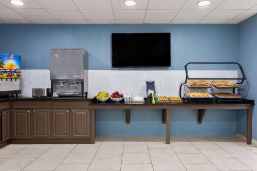 a counter in a restaurant with food on a table at Baymont by Wyndham Orlando-International Dr-Universal Blvd in Orlando