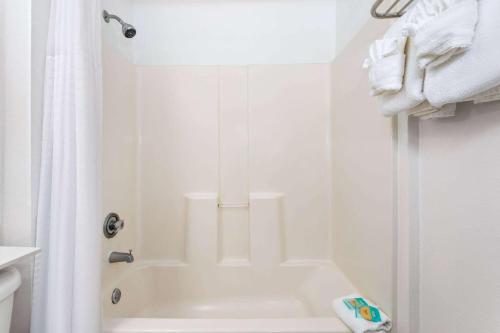 baño blanco con ducha y bañera blanca en Baymont by Wyndham Orlando-International Dr-Universal Blvd, en Orlando