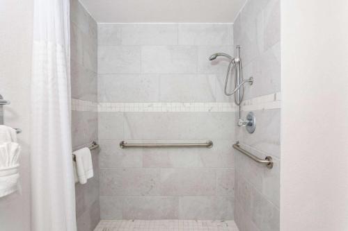 a bathroom with a shower with a shower curtain at Baymont by Wyndham Orlando-International Dr-Universal Blvd in Orlando