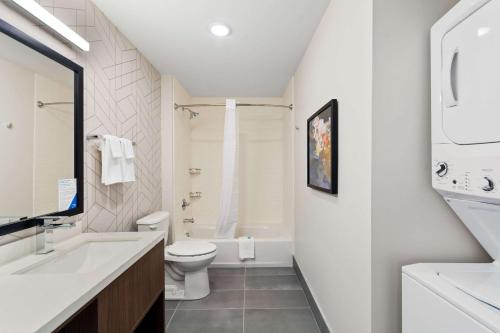a white bathroom with a toilet and a sink at Everhome Suites Lexington North in Lexington