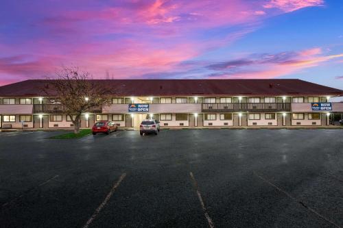 a large building with cars parked in a parking lot at Suburban Studios Peoria in Peoria