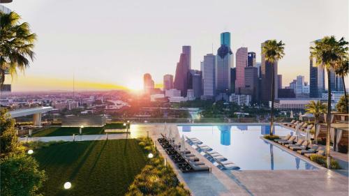 einen Pool mit Blick auf die Skyline der Stadt in der Unterkunft Thompson Houston, by Hyatt in Houston