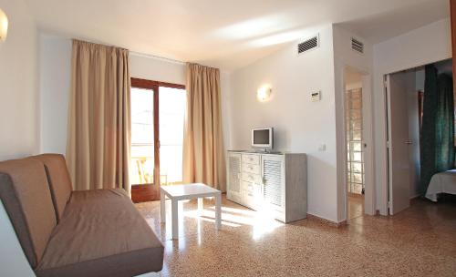 a living room with a couch and a television at Apartamentos Ripoll Ibiza in Ibiza Town