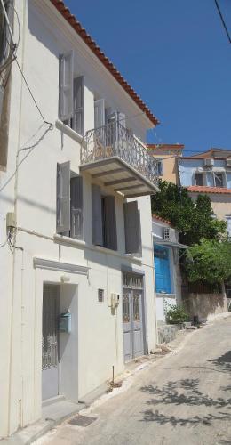 a white building with a balcony on the side of it at Soultana's Antique House in Plomarion